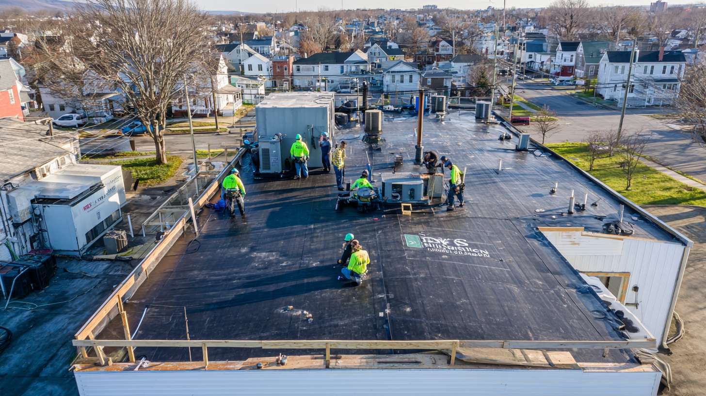 Professional roofer installing drainage system on commercial flat roof in Nassau County