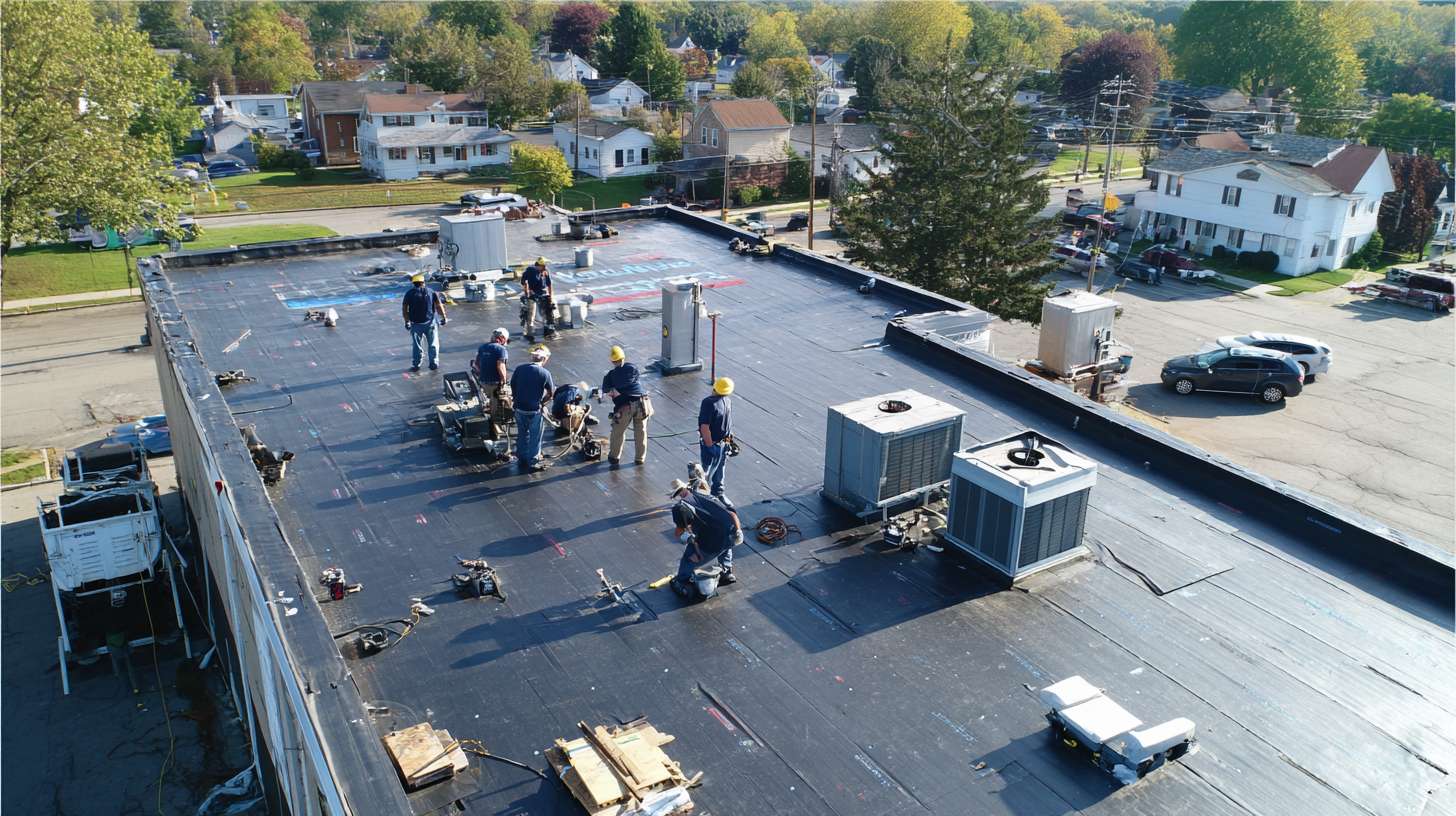 Professional roofer installing flat roofing membrane on Garden City commercial building